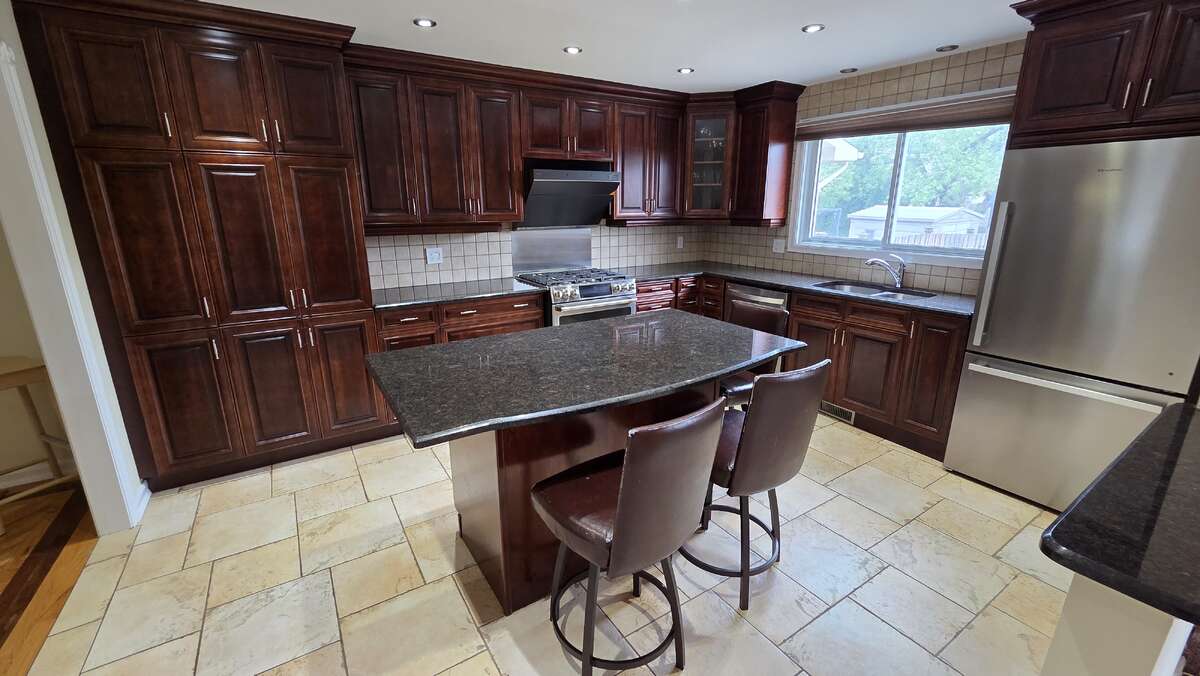 Chef's kitchen with granite island and stainless steel appliances