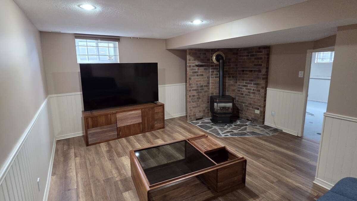 Finished basement family space with feature brick fireplace wall