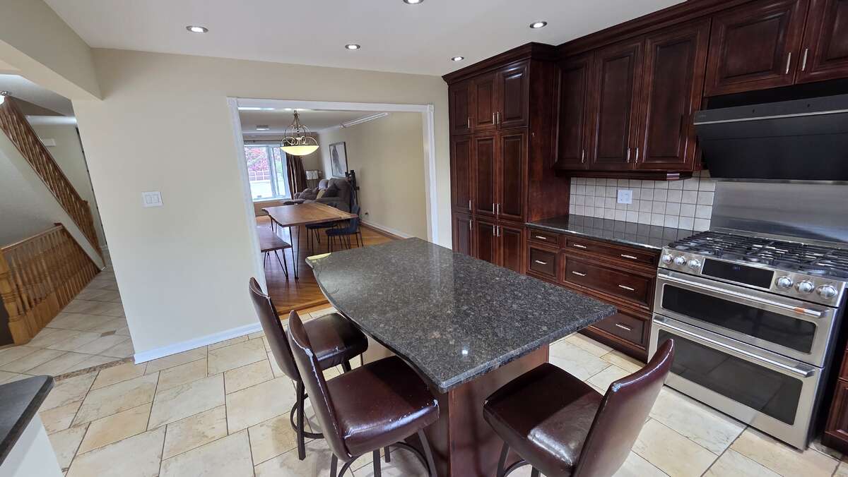 Custom dark cabinetry, granite counters, and gas range